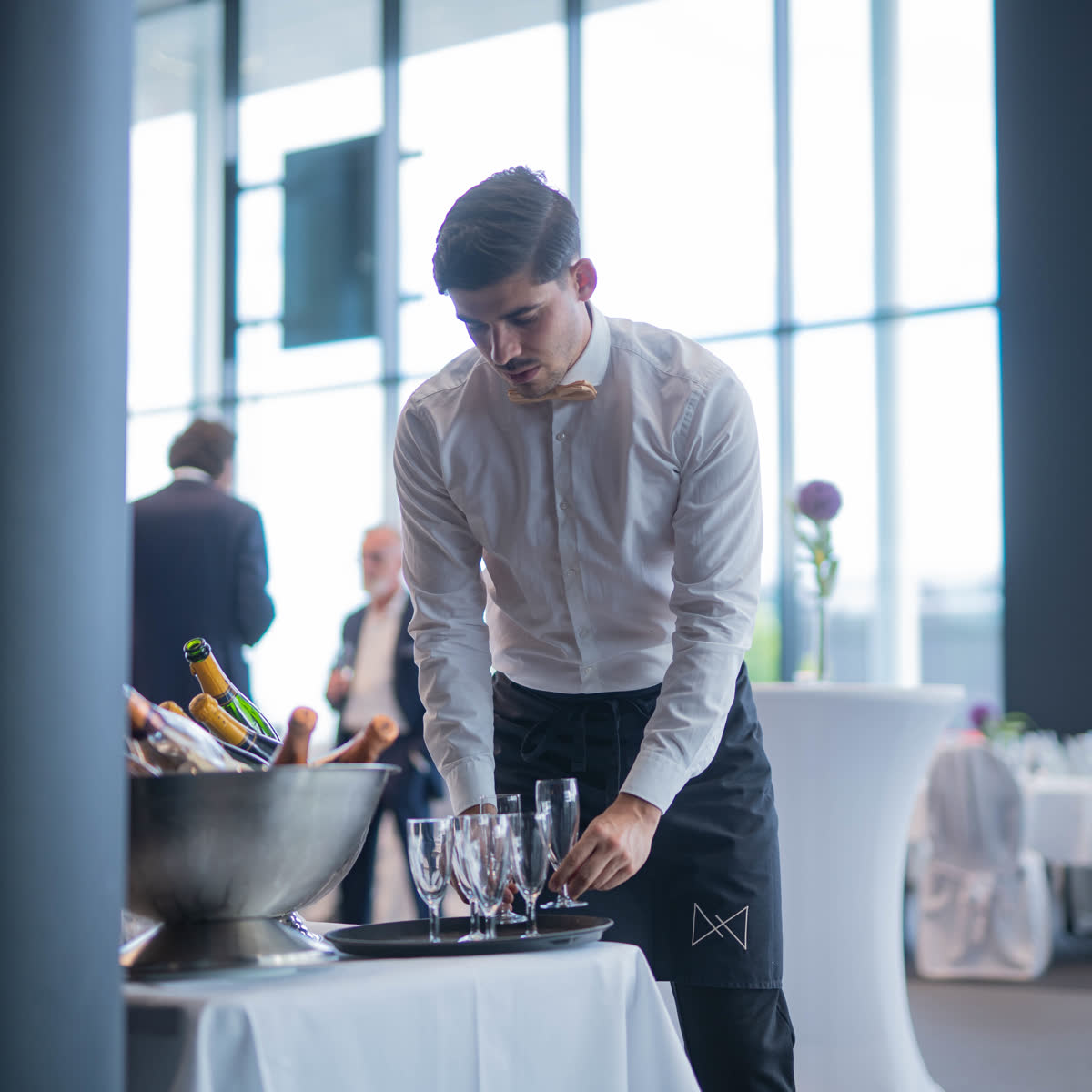 Servicekraft bereitet Champagner-Gläser vor